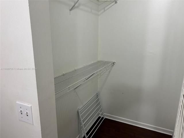 walk in closet with dark wood-type flooring