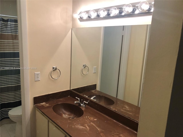 bathroom featuring tile patterned flooring, vanity, and toilet