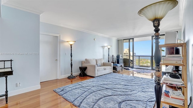 bedroom with a wall of windows, ornamental molding, and light hardwood / wood-style flooring