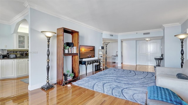 living room with crown molding and light wood-type flooring