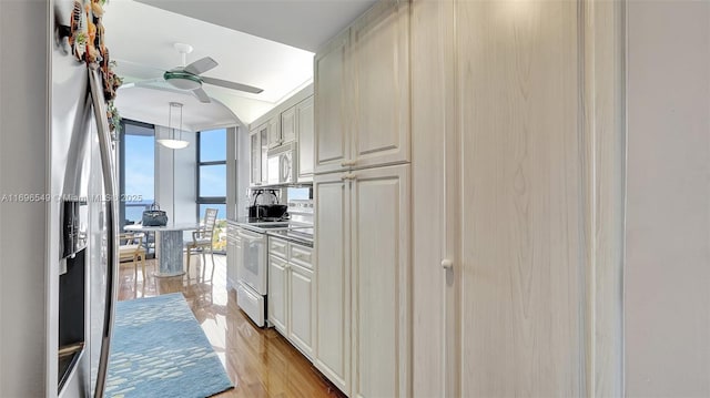 kitchen featuring decorative light fixtures, ceiling fan, light hardwood / wood-style floors, white appliances, and cream cabinetry