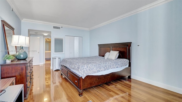 bedroom with crown molding, a closet, and light wood-type flooring