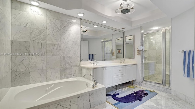 bathroom featuring a raised ceiling, plus walk in shower, and vanity