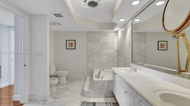 bathroom featuring a bidet, a relaxing tiled tub, vanity, and toilet