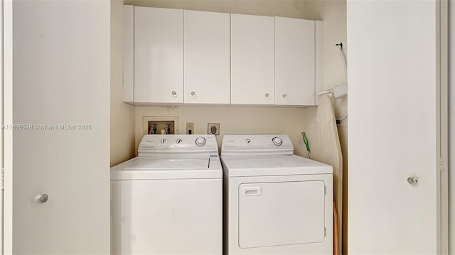 clothes washing area with cabinets and washer and dryer