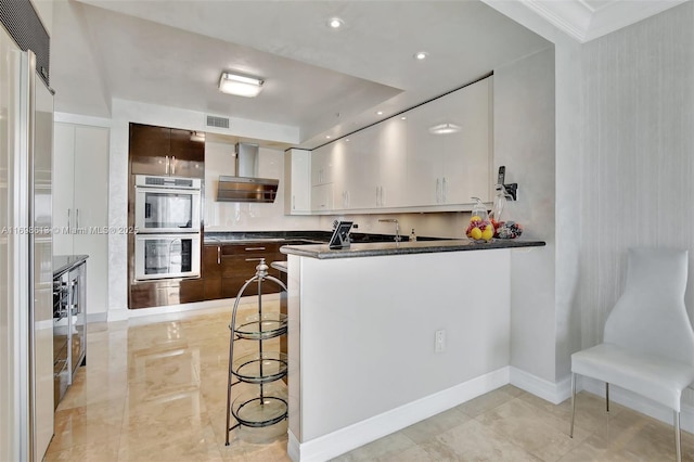 3201 NE 183rd St Unit 2607, Aventura, FL 33160 - kitchen with appliances with stainless steel finishes, wall chimney range hood, white cabinets, crown molding, and dark brown cabinets