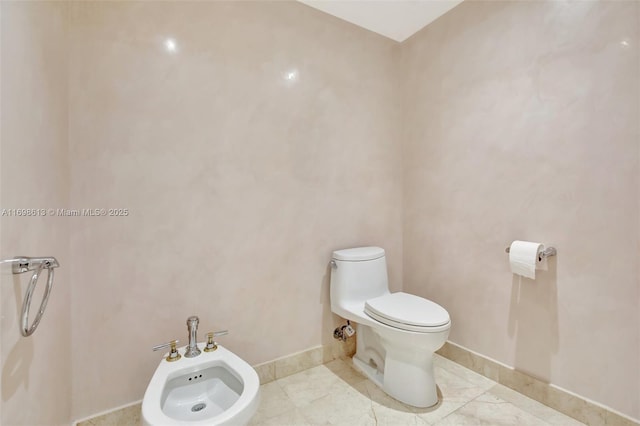 bathroom with tile patterned flooring, toilet, and a bidet