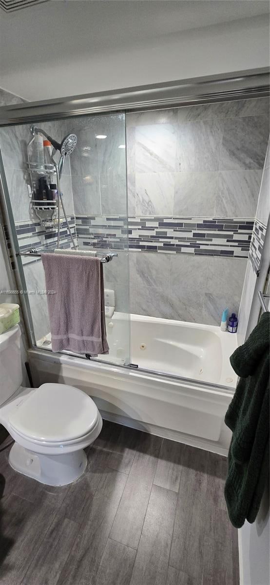 bathroom with shower / bath combination with glass door, toilet, and hardwood / wood-style flooring