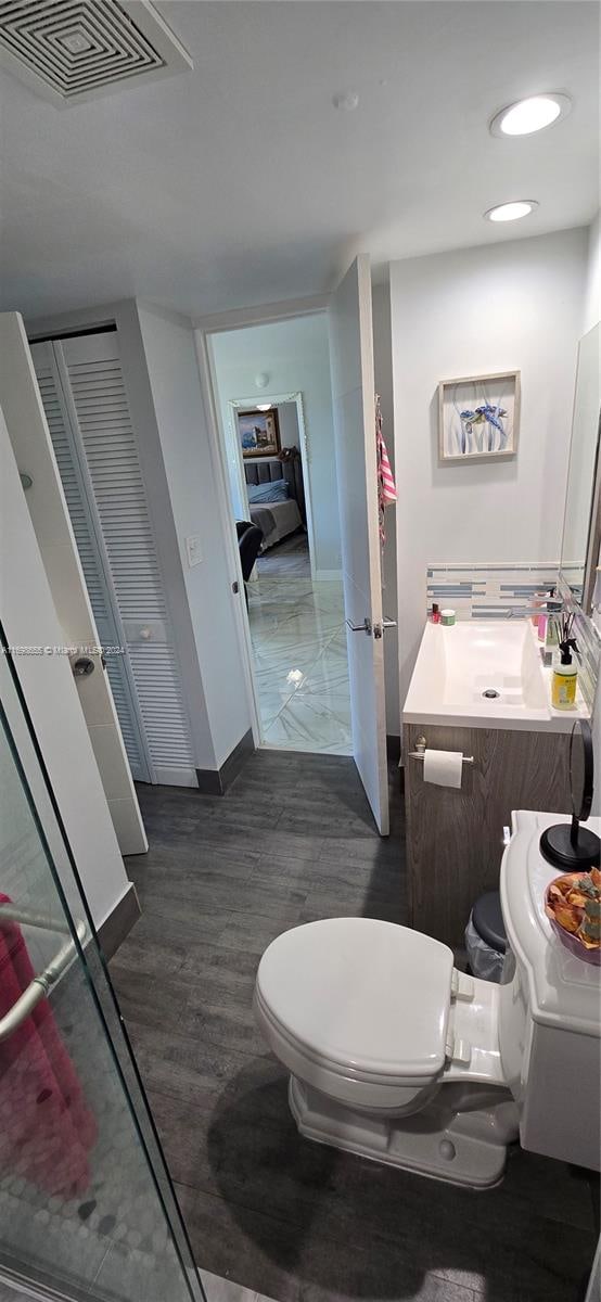 bathroom with hardwood / wood-style flooring, vanity, and toilet