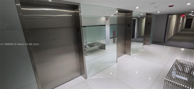 corridor with elevator and light tile patterned flooring