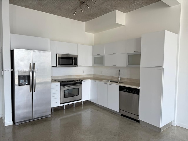 kitchen with white cabinetry, stainless steel appliances, sink, and a high ceiling