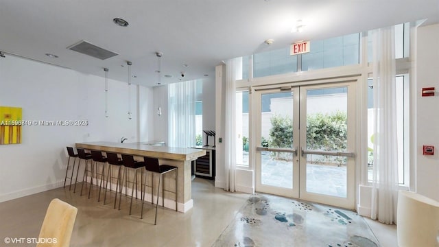 kitchen with a breakfast bar, kitchen peninsula, beverage cooler, and french doors