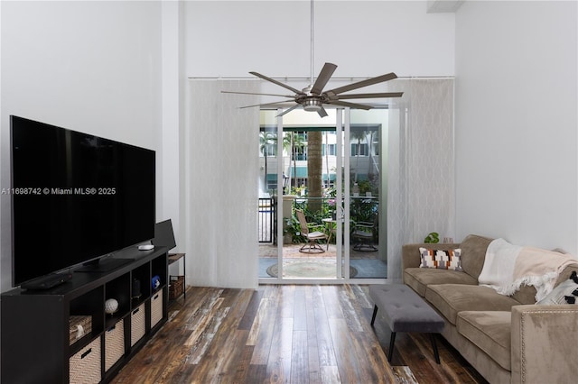 living room with ceiling fan and dark wood-type flooring