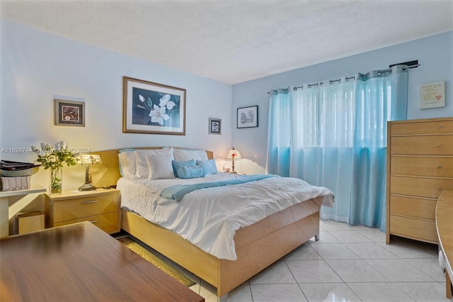 bedroom with light tile patterned floors and a textured ceiling