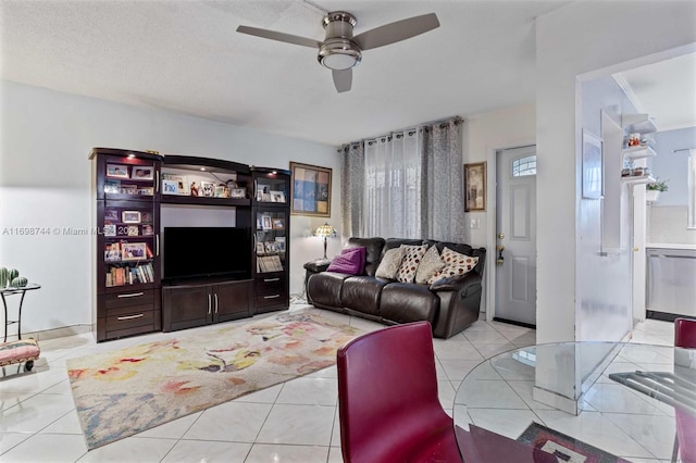 living room featuring a textured ceiling, ceiling fan, and light tile patterned flooring