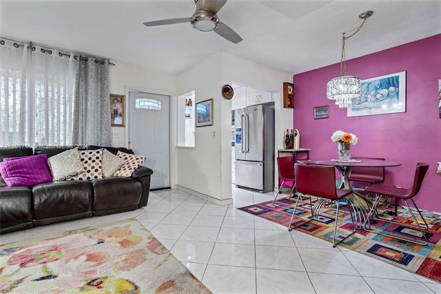 living room featuring plenty of natural light, light tile patterned floors, and ceiling fan with notable chandelier