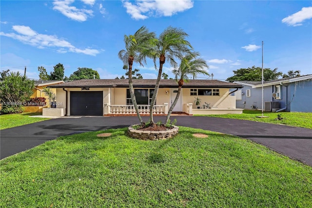 single story home with covered porch, a garage, central air condition unit, and a front lawn