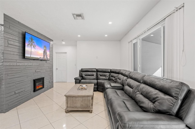 living room featuring light tile patterned floors and a stone fireplace