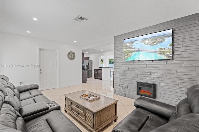 tiled living room featuring a stone fireplace