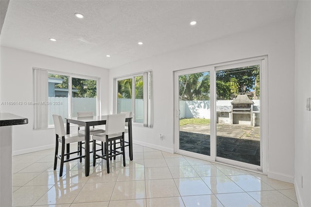 tiled dining space with a textured ceiling