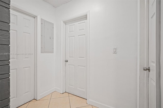 hallway with light tile patterned floors and electric panel