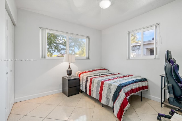 bedroom with a closet, multiple windows, and light tile patterned flooring