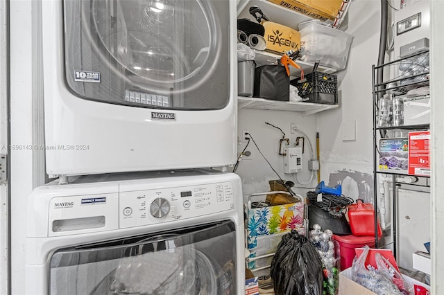 clothes washing area featuring stacked washing maching and dryer