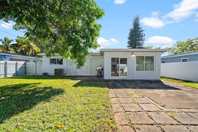 rear view of house featuring a lawn, a patio area, and central air condition unit