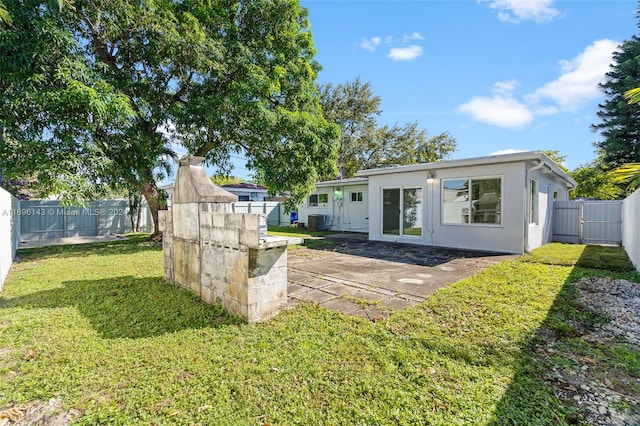 back of house featuring a lawn and cooling unit