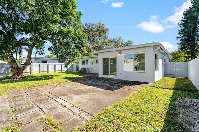 rear view of house featuring a lawn, a patio area, and central AC