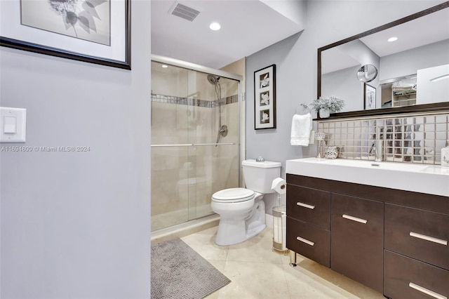 bathroom with tile patterned flooring, vanity, toilet, and a shower with shower door