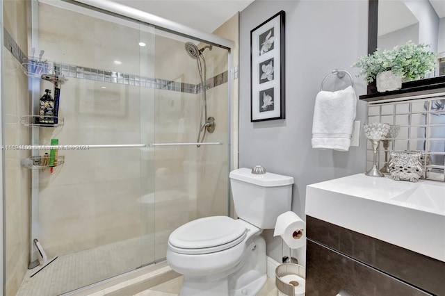 bathroom with vanity, a shower with shower door, and toilet