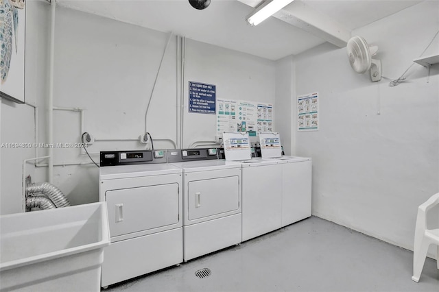 clothes washing area featuring washer and clothes dryer and sink