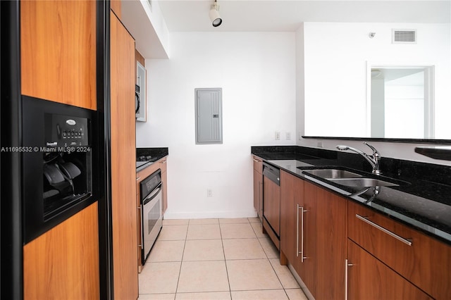 kitchen featuring appliances with stainless steel finishes, electric panel, sink, and dark stone counters