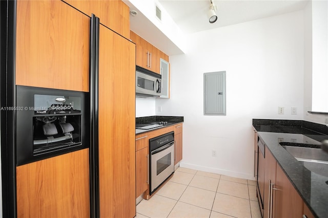 kitchen featuring sink, stainless steel appliances, electric panel, dark stone countertops, and light tile patterned floors