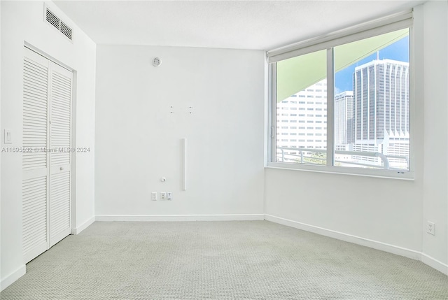 unfurnished bedroom with a closet and light colored carpet