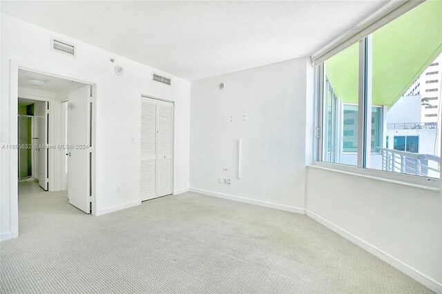 carpeted spare room featuring a textured ceiling