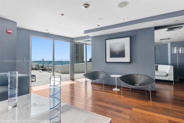 living room with a water view and hardwood / wood-style flooring