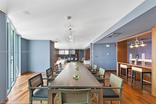 dining area featuring wood-type flooring and an inviting chandelier