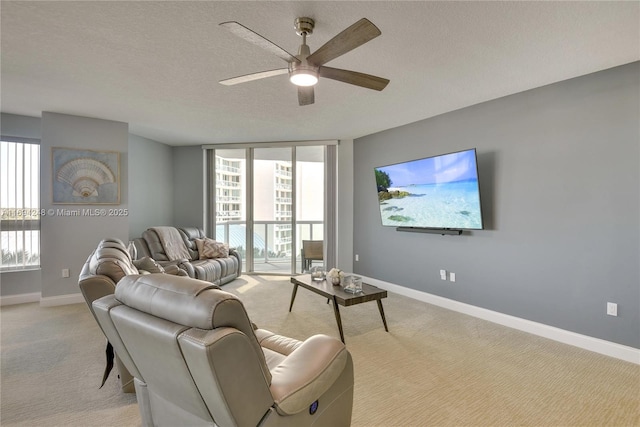 carpeted living room featuring ceiling fan, floor to ceiling windows, and a textured ceiling