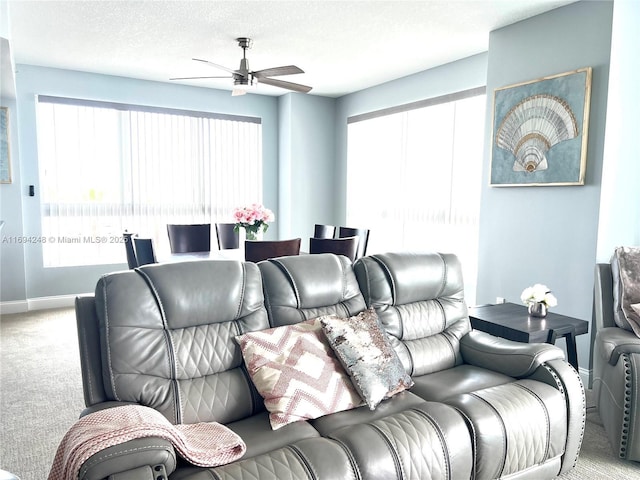 home theater room with ceiling fan, plenty of natural light, carpet floors, and a textured ceiling