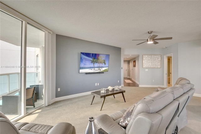 carpeted living room featuring ceiling fan, a textured ceiling, and a wall of windows