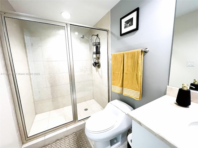 bathroom with vanity, toilet, and a shower with shower door