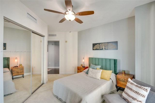 carpeted bedroom featuring ceiling fan and a closet