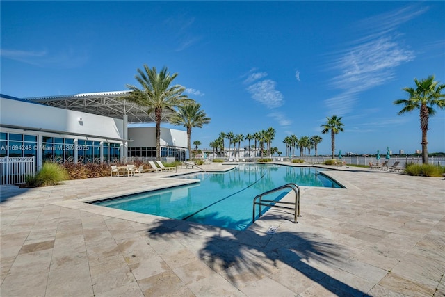 view of swimming pool with a water view and a patio area