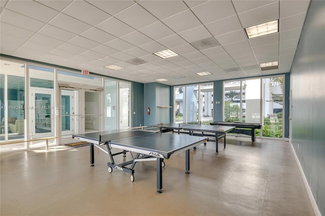 recreation room featuring expansive windows, a drop ceiling, and french doors