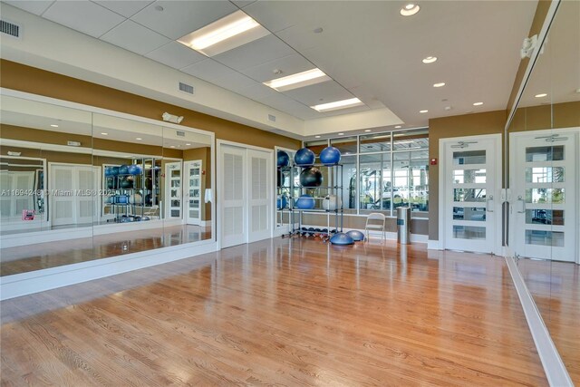 gym featuring hardwood / wood-style flooring and french doors