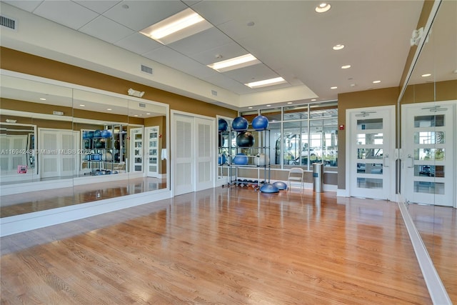 workout area with hardwood / wood-style floors and french doors