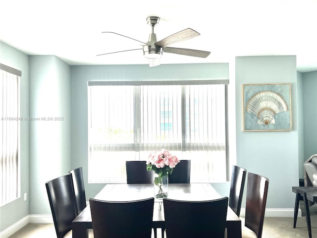 carpeted dining space with ceiling fan