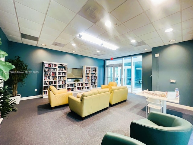 living room featuring a paneled ceiling and carpet flooring